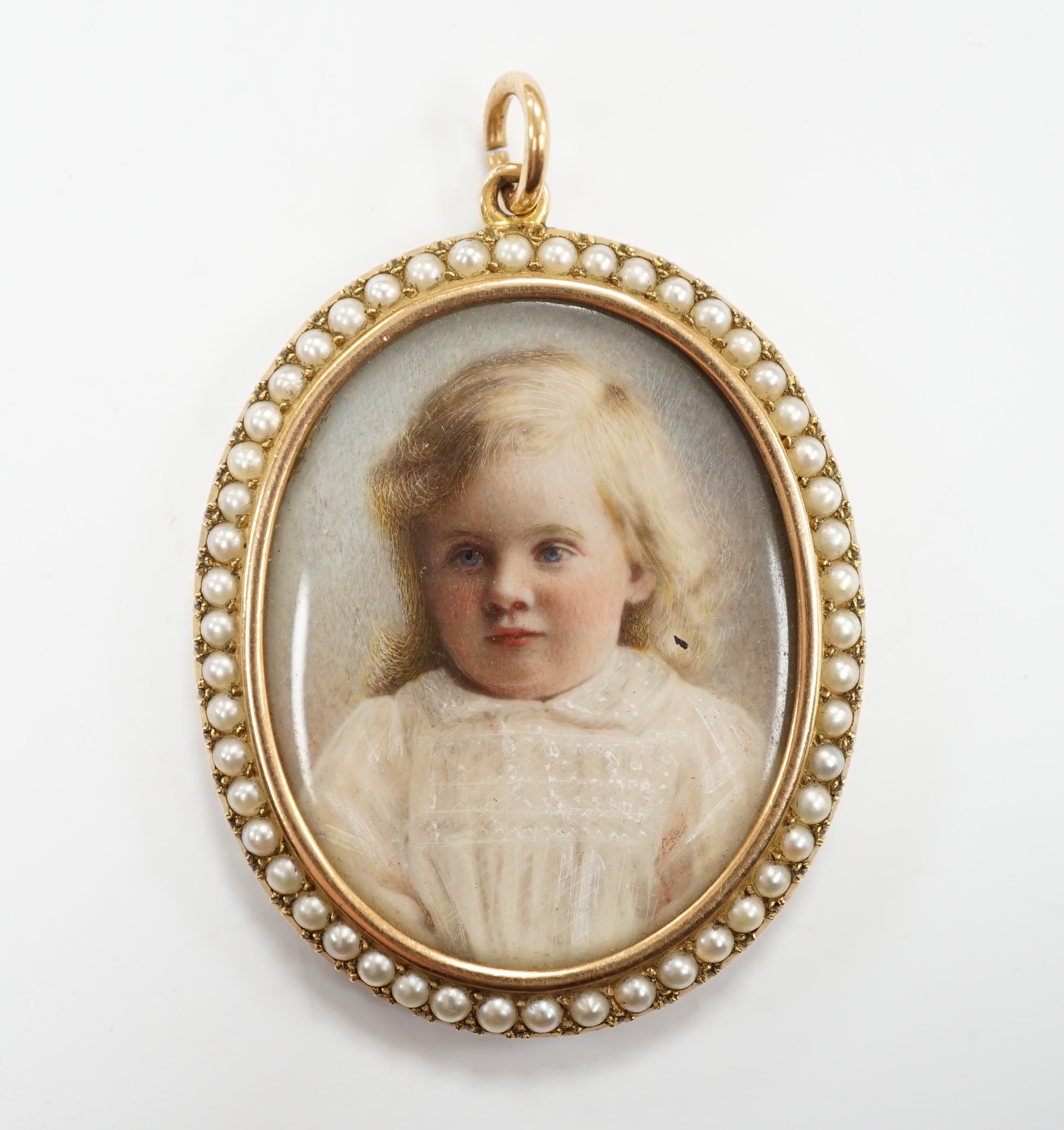 An Edwardian unmarked yellow metal and half pearl oval double sided pendant each side containing a miniature of a young girl, (unsigned), 4 x 3.5cm. CITES Submission reference 8GACTKGJ